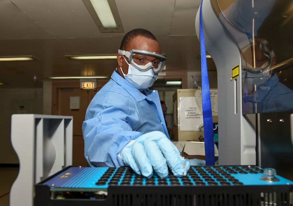 A handout photo made available by the US Navy shows Hospital Corpsman 1st Class Kossi Fandoumi, a laboratory technician onboard the hospital ship USNS Comfort (T-AH 20), testing plasma samples in support to the national coronavirus disease (COVID-19) pandemic, in New York, New York, USA, 19 April 2020 (issued 24 April 2020). Comfort cares for critical and non-critical patients without regard to their COVID-19 status.